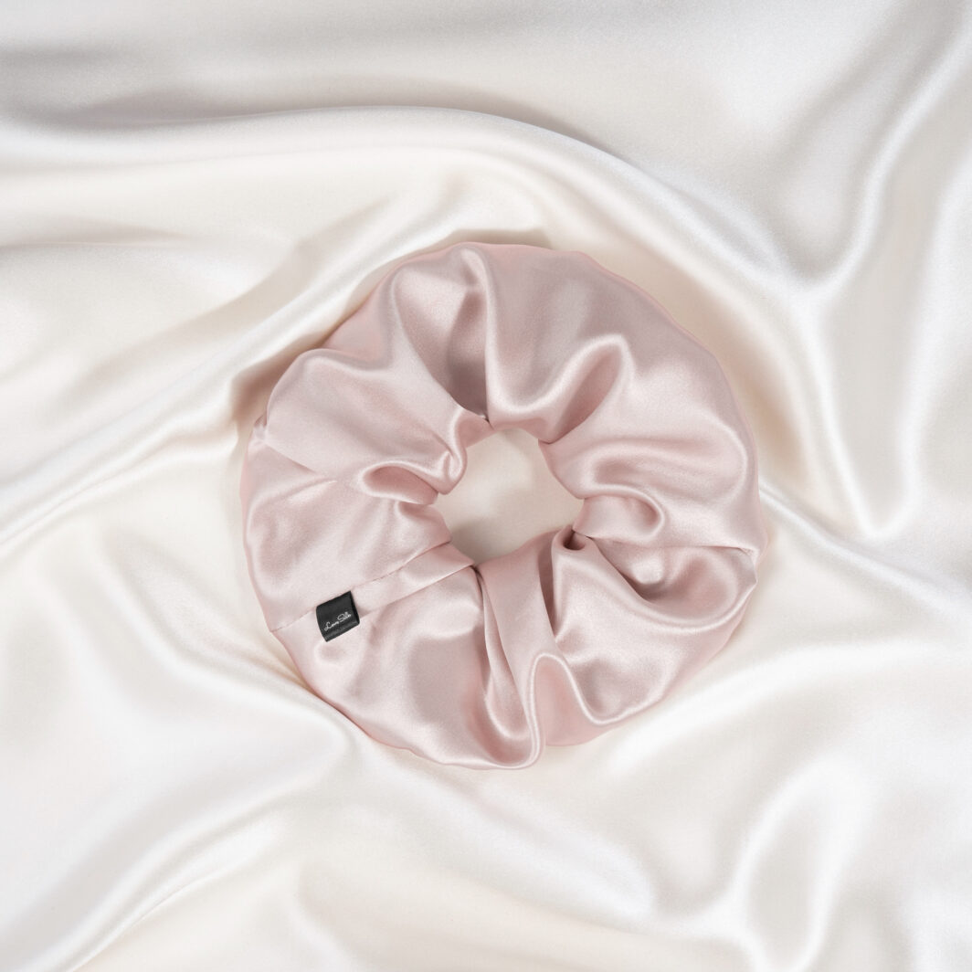 Seidenhaarband aus rosa Satin auf weißem Seidenschal.