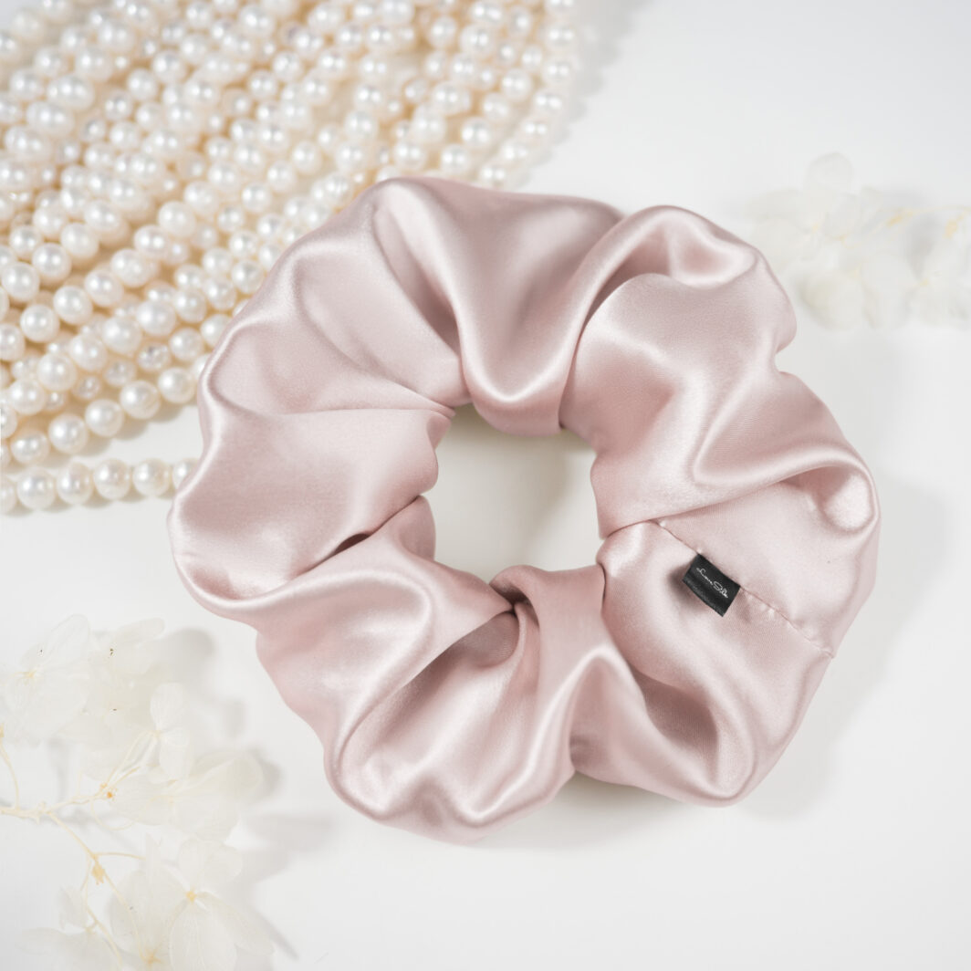 Soft rosa Seidenschal mit Satin-Optik, zusammengeschoben, elegantes Accessoire aus Seide.