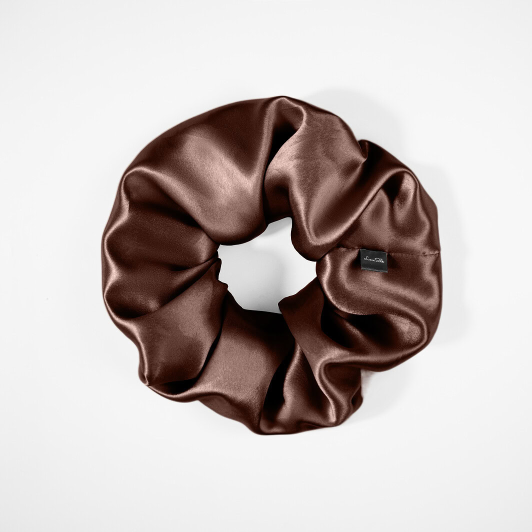 Wechselnder Seidenhaargummi in schimmerndem Braun für eleganten Look.