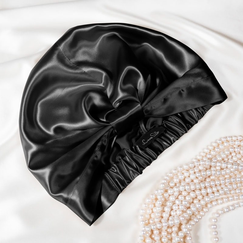 Edler Seidenkissenbezug aus Satin, schwarz, mit Luxusverschluss auf Seide-Bettwäsche.