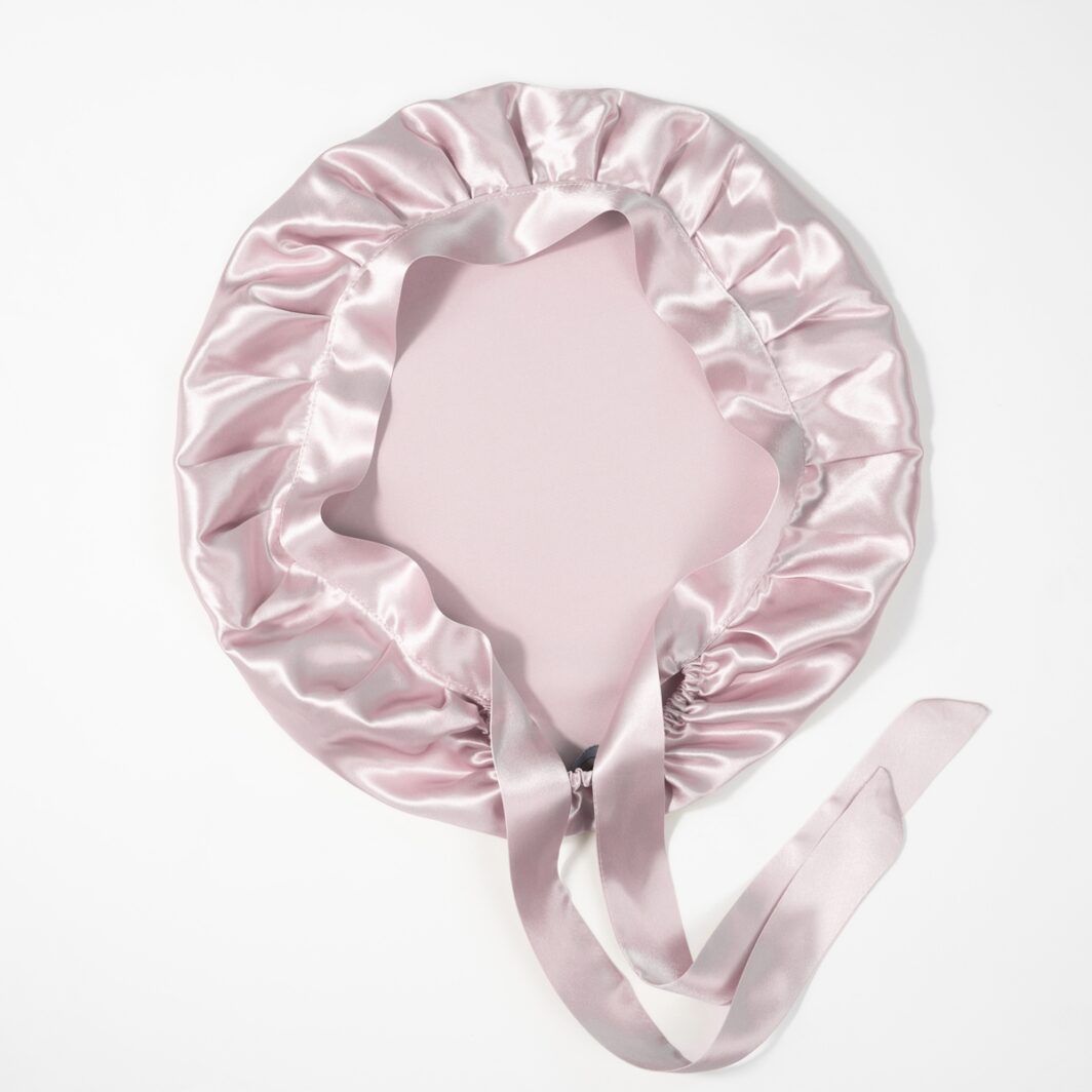 Seidenkissenbezug mit Rüschen und Satinband in zartem Rosé, luxuriöses Accessoire fürs Bett.