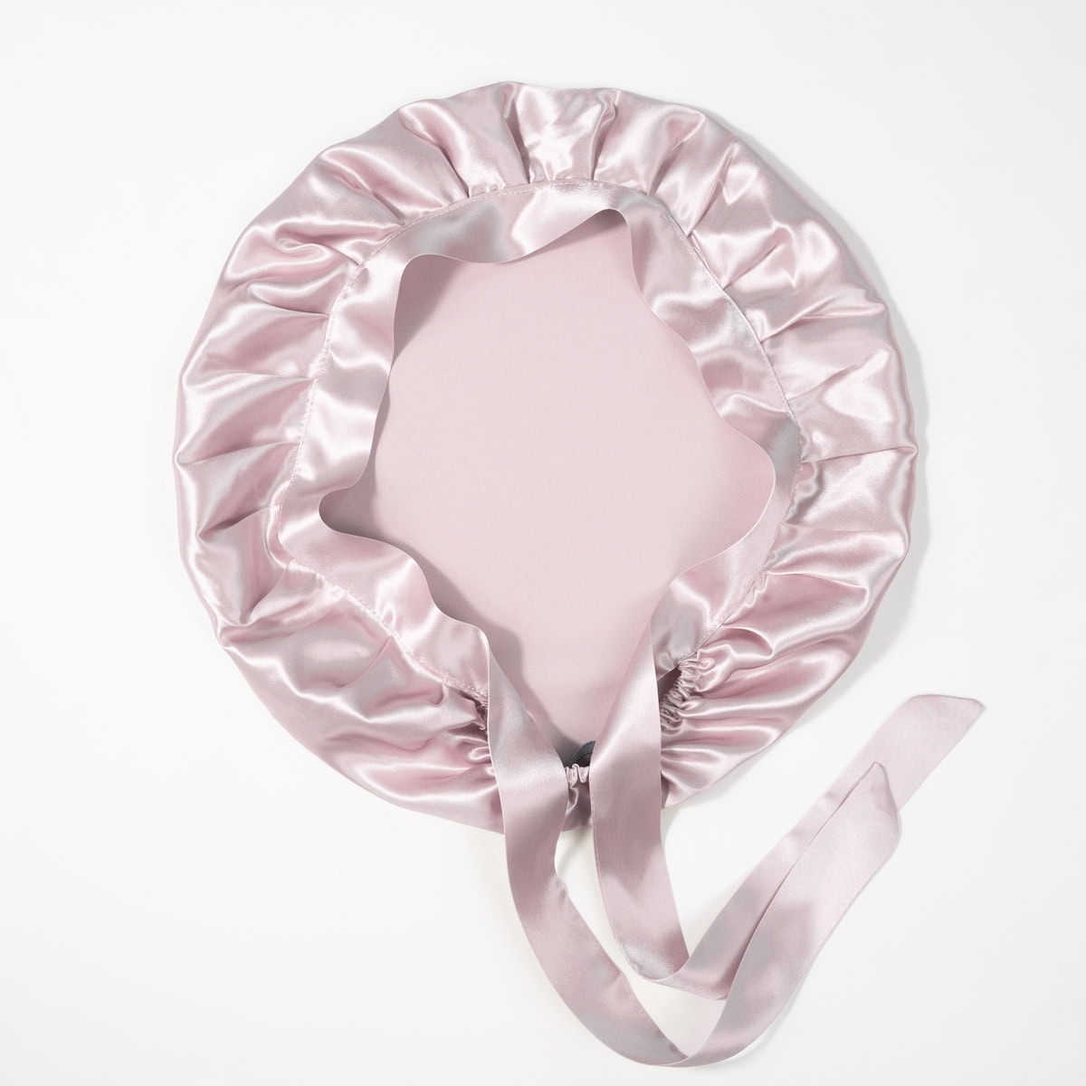 Seidenkissenbezug mit Rüschen und Satinband in zartem Rosé, luxuriöses Accessoire fürs Bett.