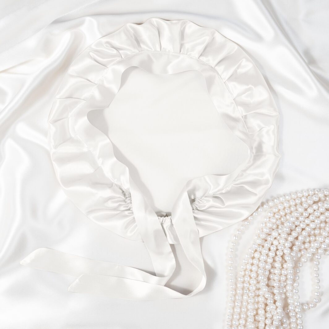 Seidenkissenbezug aus Satin mit Rüschendetails und Perlen, luxuriöses Accessoire für ein elegantes Schlafzimmer.