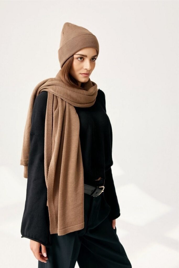 Weicher Seidenschal und Mütze in Beige, stilvoll kombiniert für kalte Tage.
