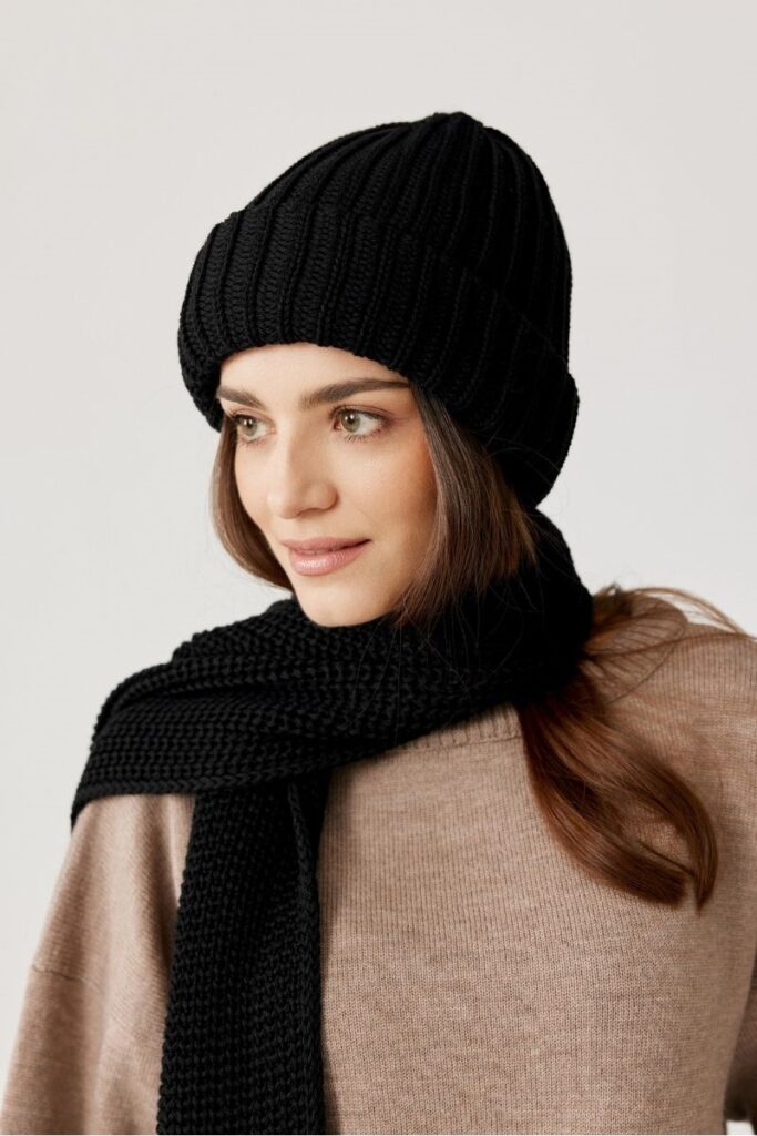 Schwarzer gestrickter beanie und schal aus wolle, modisch und warm.
