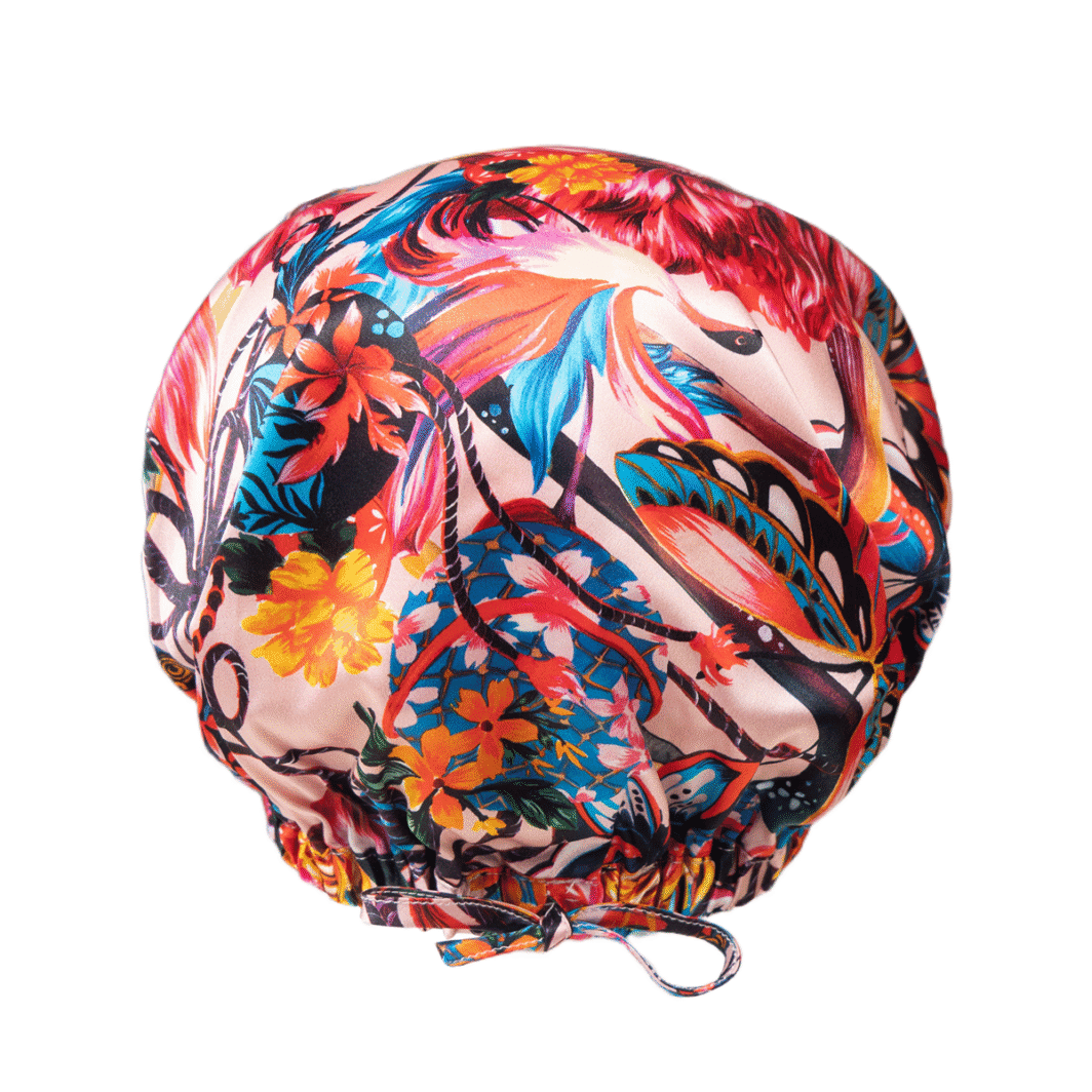 Weißer Seidenkissenbezug mit buntem, tropischem Blumen- und Blättermuster.