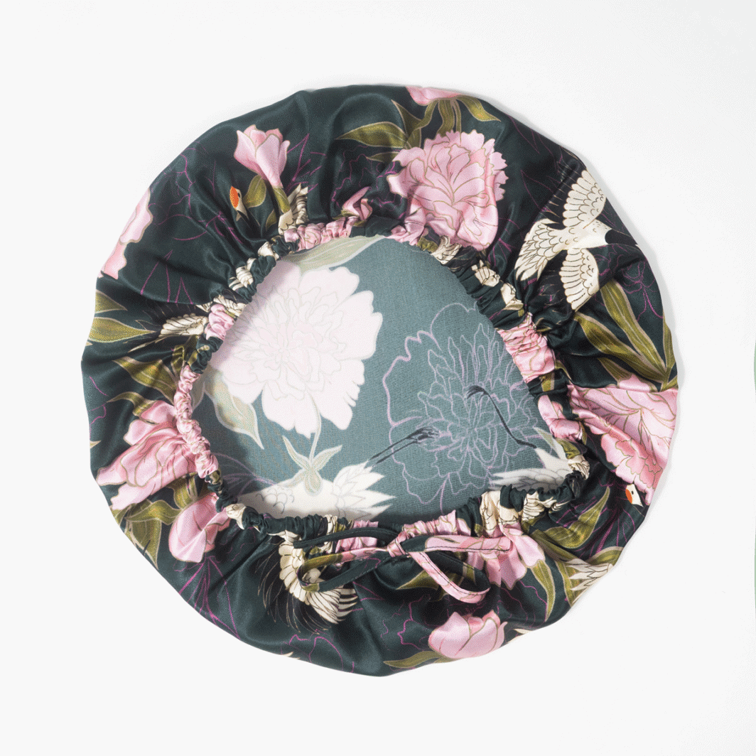 Weißes Seidenkissen mit floraler Gestaltung und schwarzen, pinken und grünen Akzenten, ideal für edlen Schlafkomfort.